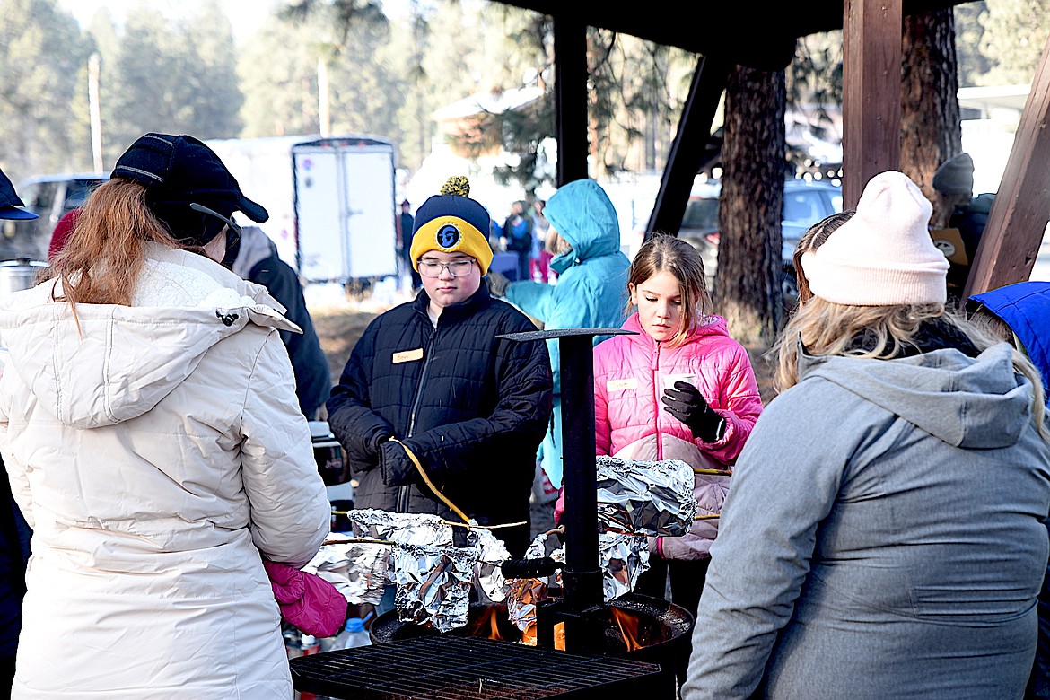 Libby fifth-grade students cook their lunch over an open fire during the Friends of Scotchman Peaks Wilderness Libby Winter Tracks event Friday, Jan. 24, 2025, at J. Neils Memorial Park. (Scott Shindledecker/The Western News)