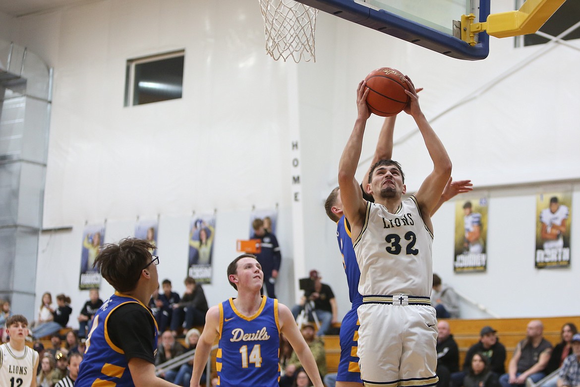 MLCA/CCS junior Dennis Gulenko (32) rises up to lay the ball in for a basket against Wilson Creek on Thursday.