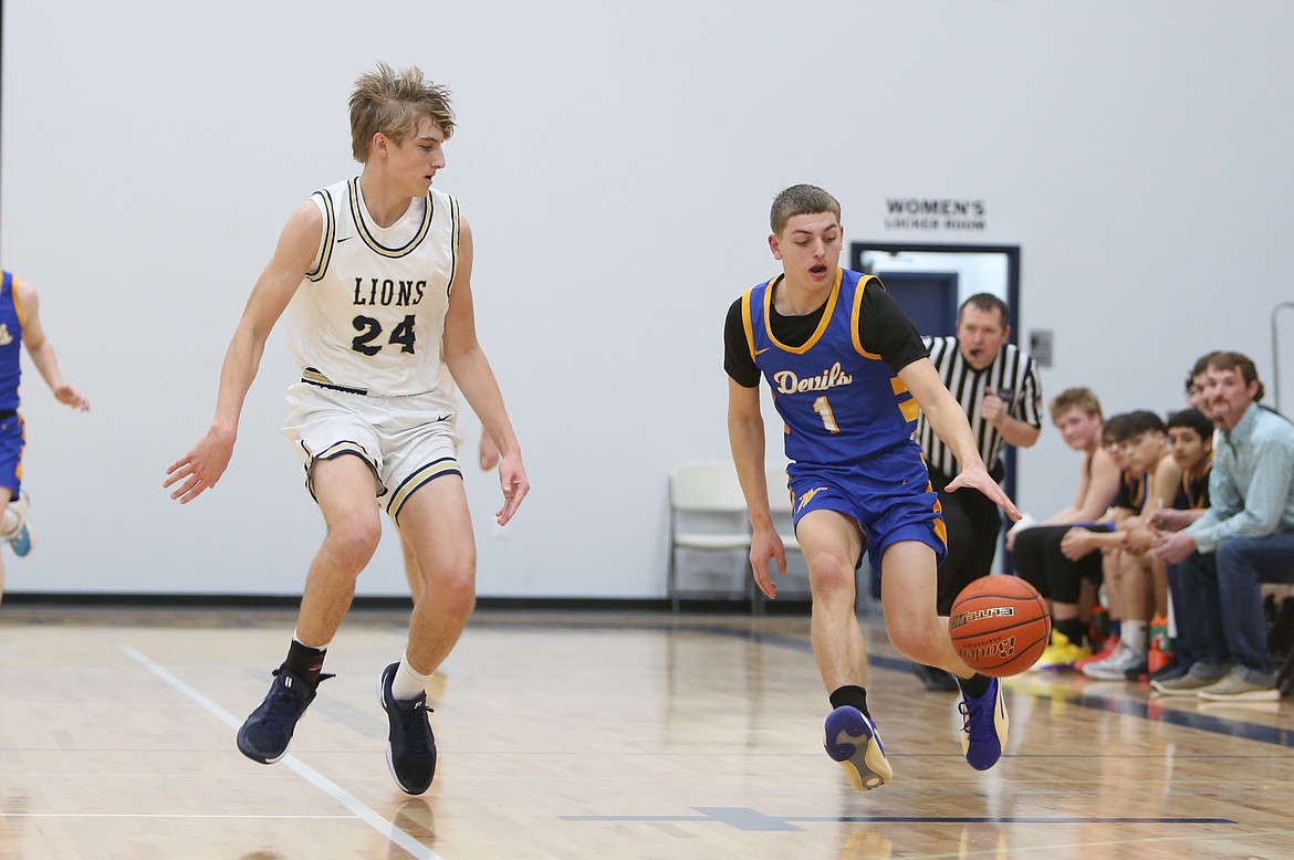 Wilson Creek sophomore Landon McMillan, right, brings the ball up the floor against MLCA/CCS on Thursday night. McMillan led the Devils with eight points.