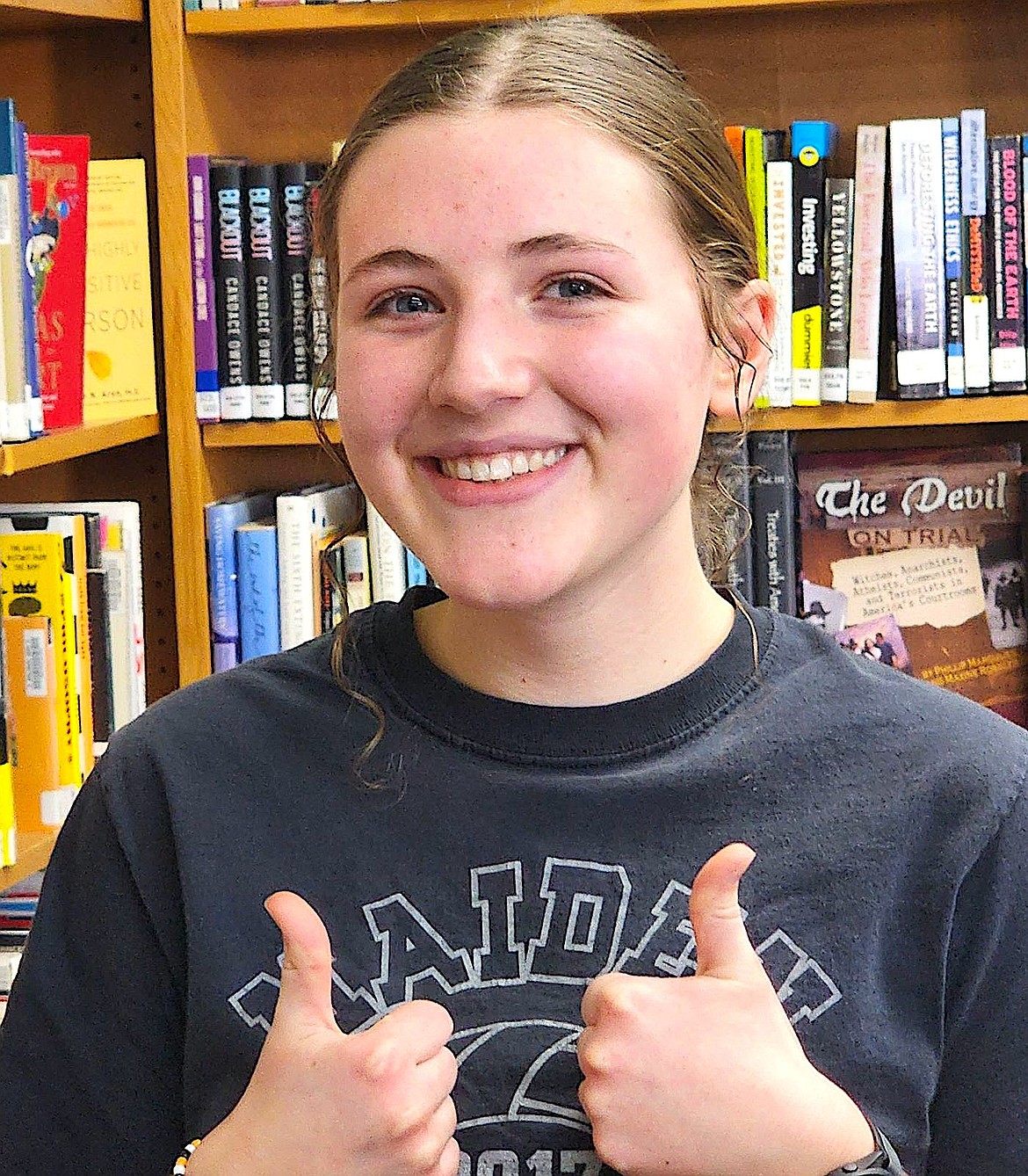 Grace Heiner gives a thumbs up to the world in the Ronan High School Library. (Berl Tiskus/Leader)