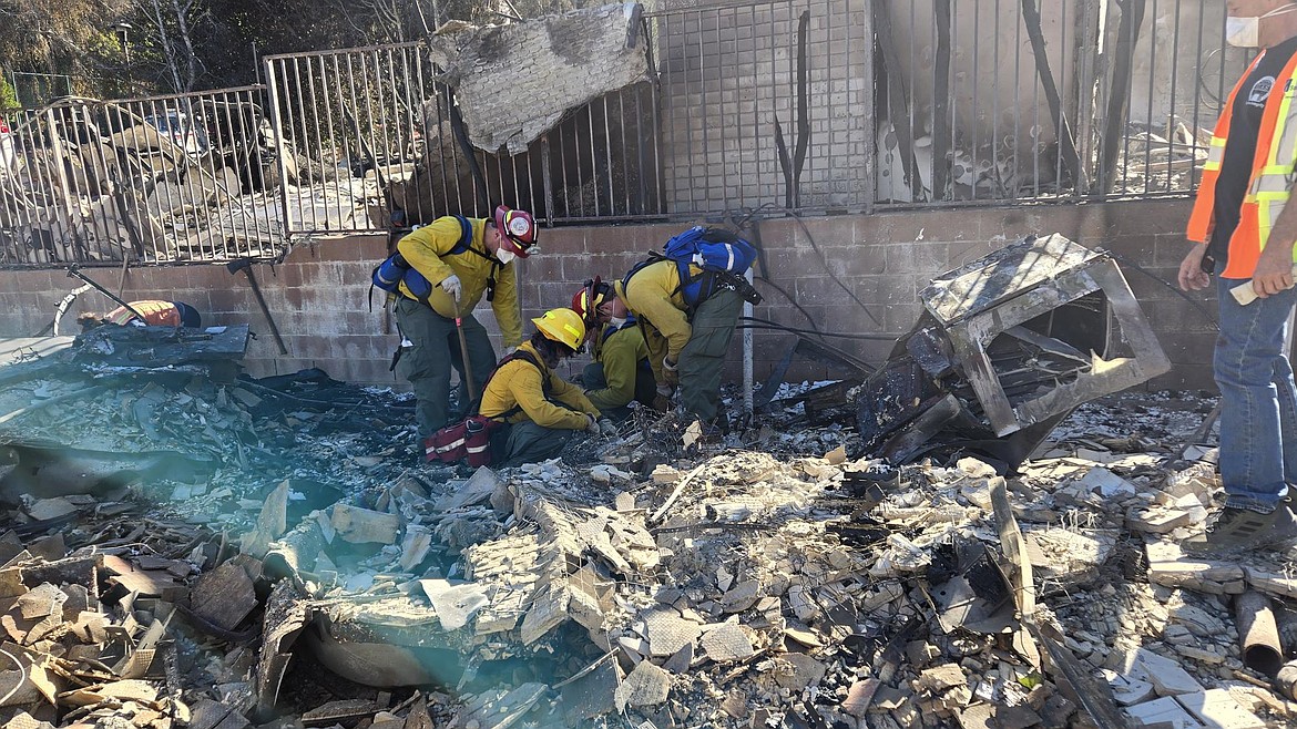 Crews from Shoshone County Fire District #2 sift through debris from a home that was lost in the Palisades Fire near Los Angeles.