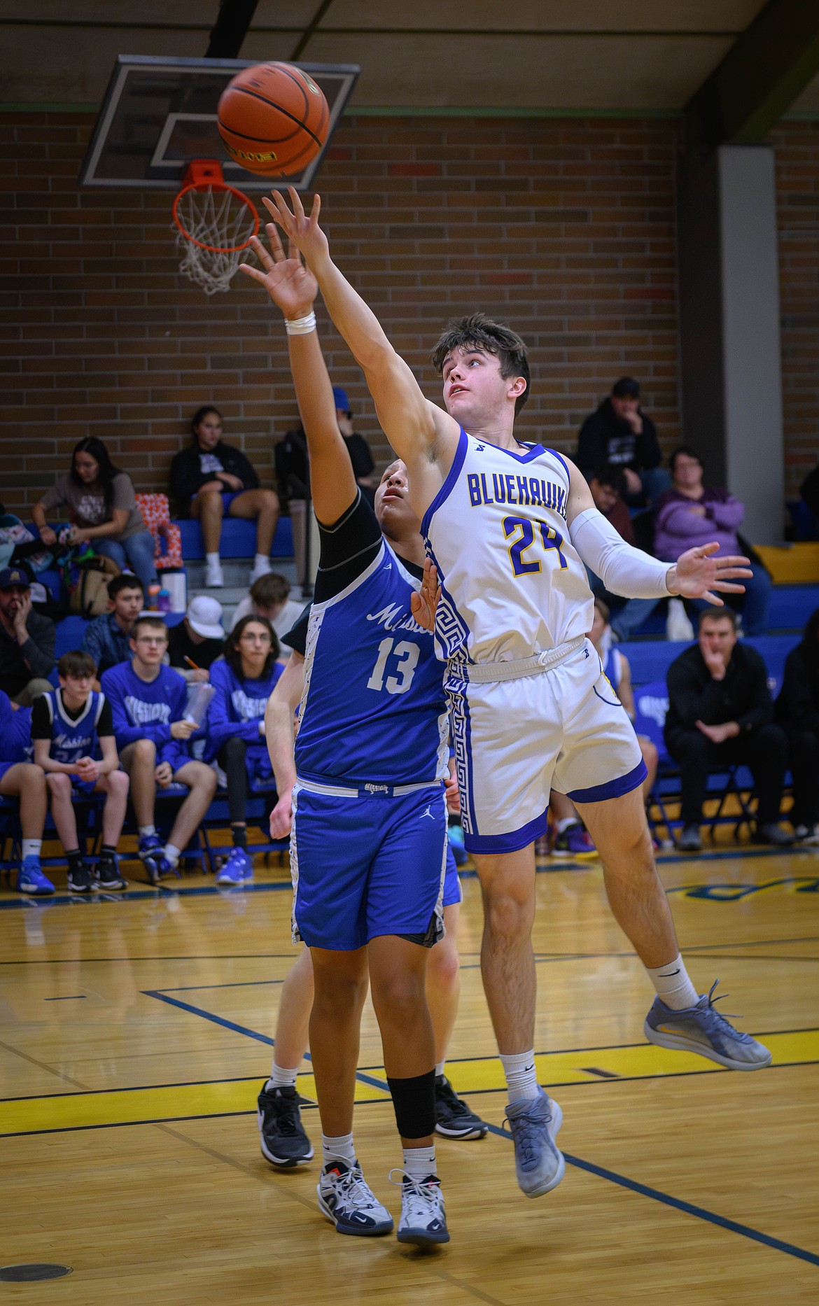 Blue Hawks forward Braedon Ferris puts up a shot over St. Ignatius' Vinny Shepard during their game this past week in T Falls. (Tracy Scott/Valley Press)