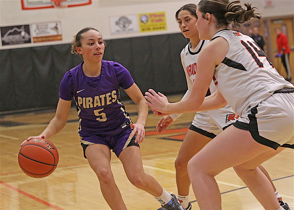 Polson's Rylee Taylor-Jefferson, who crossed the 300-point career milestone in Saturday's game, tries to evade a double attack of Ronan Maidens. (Bob Gunderson photo)