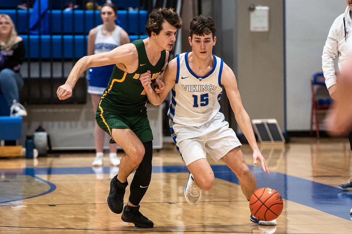 Austin Savik muscles past Whitefish's Carson Gulick in Thursday's game. (Avery Howe/Bigfork Eagle)