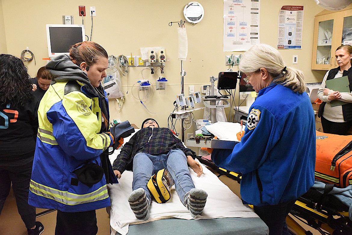 Troy Volunteer Ambulance's Bobbie Scott, left, and Janet Miller look over their patient, 'Lucy,' Wednesday, Feb. 5, 2024, during a Simulation in Motion Montana healthcare training session at Cabinet Peaks Medical Center in Libby. (Scott Shindledecker/The Western News)