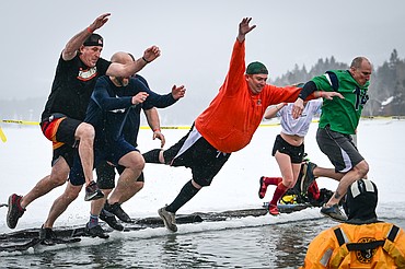 The Kalispell Public Schools team jumps into Whitefish Lake at the Penguin Plunge at City Beach on Saturday, Feb. 8. Organized by the Law Enforcement Torch Run, as part of the Whitefish Winter Carnival, the event raises money for Special Olympics Montana. (Casey Kreider/Daily Inter Lake)