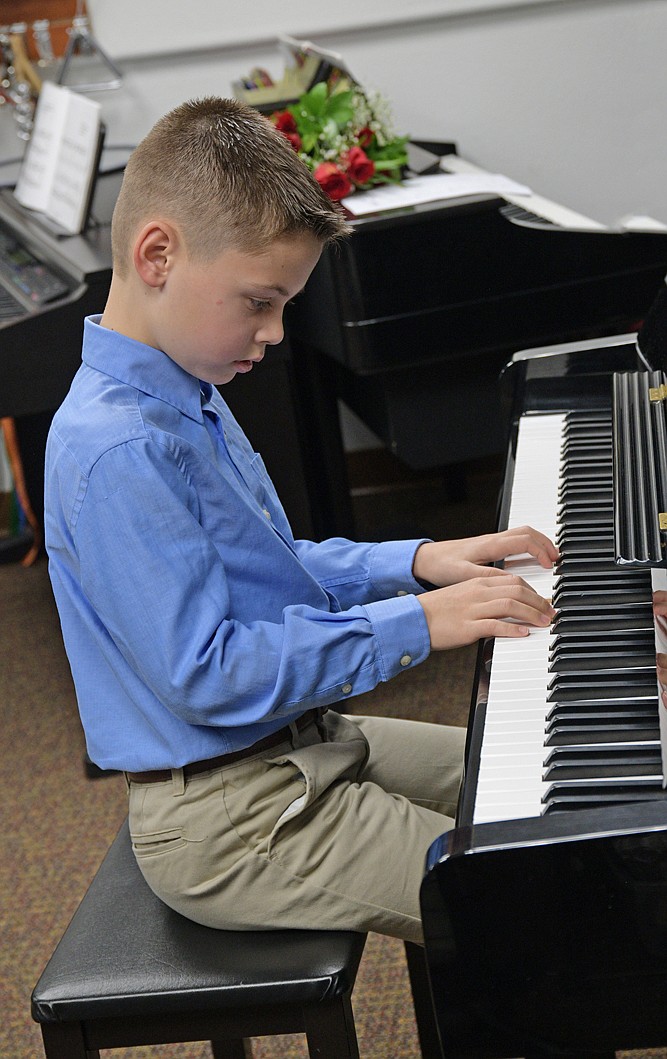 A student practices piano at the Northwest Music Academy. When the pandemic hit, the audience for music lessons expanded and the business had to a bigger location to keep up.