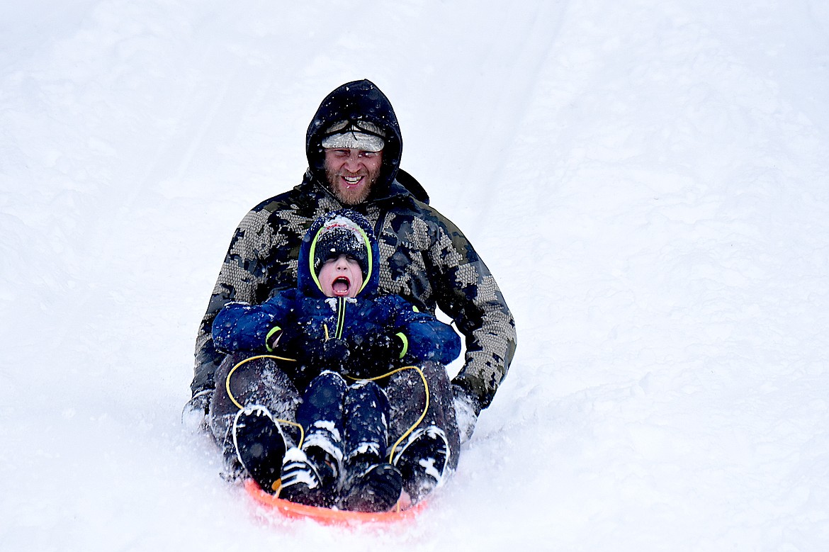 Ward Bland, of Libby, and his son, Oliver, enjoy a sled ride down the hill Sunday, Feb. 16, 2025, behind Libby Elementary School. (Scott Shindledecker/The Western News)