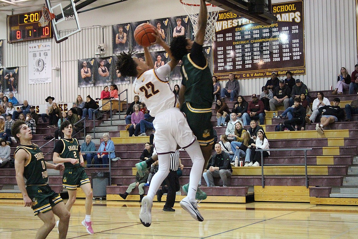 Moses Lake junior Tyce Miller (22) drives toward the rim during a game against Shadle Park on Dec. 30.