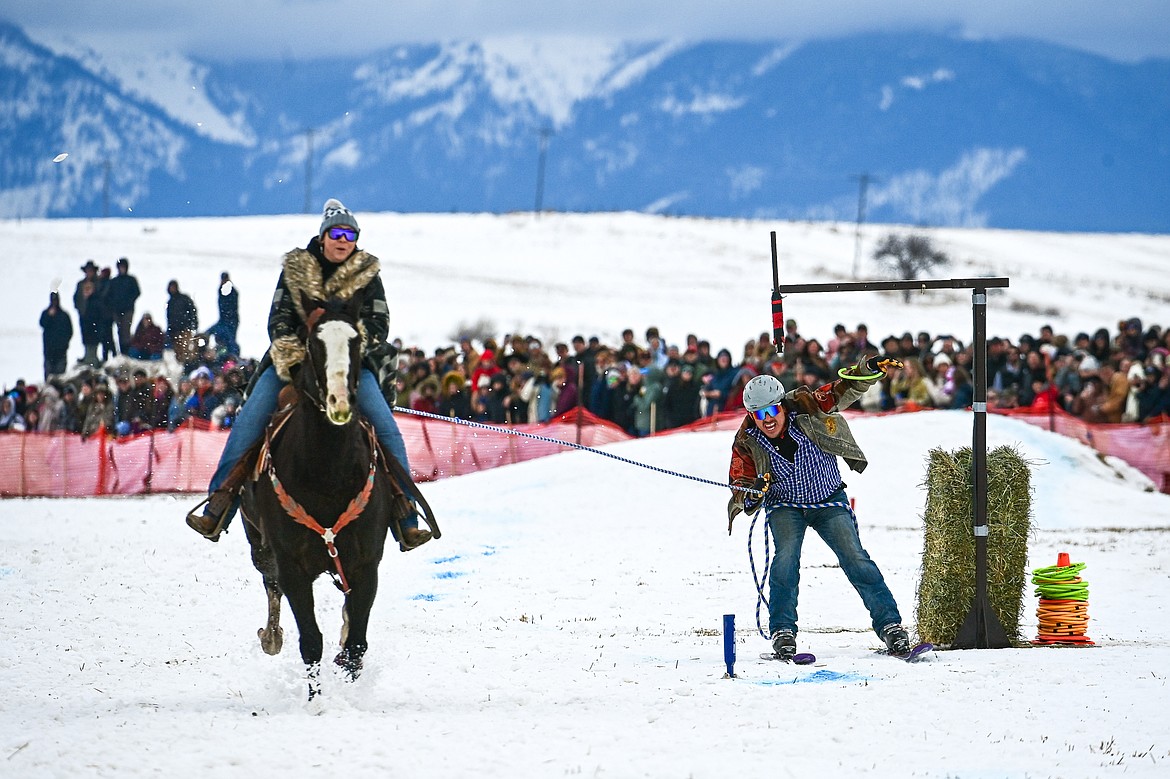 A skier secures a ring as he's pulled through the course at Whitefish Skijoring on West Springcreek Road on Saturday, Feb. 22. (Casey Kreider/Daily Inter Lake)