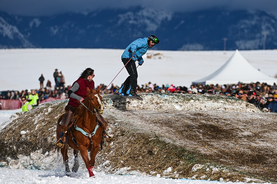 A horseback rider pulls a snowboarder over a jump at Whitefish Skijoring on West Springcreek Road on Saturday, Feb. 22. (Casey Kreider/Daily Inter Lake)