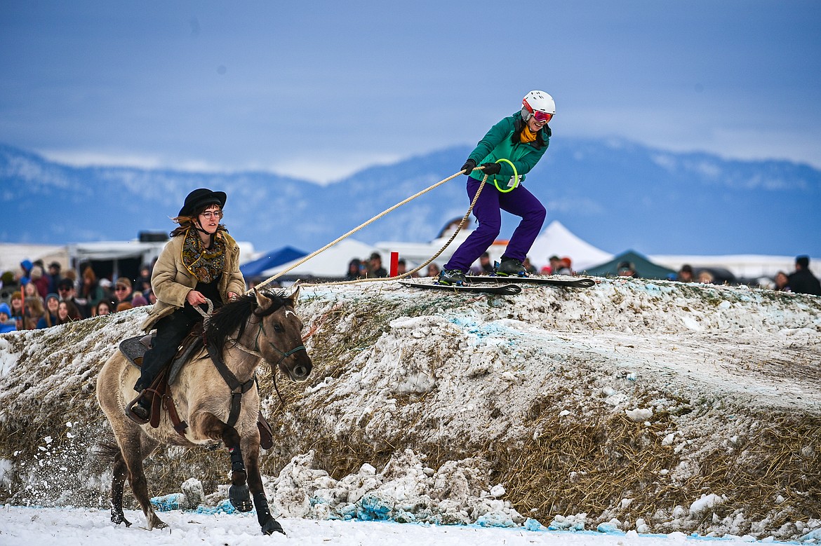 A horseback rider pulls a skier over a jump at Whitefish Skijoring on West Springcreek Road on Saturday, Feb. 22. (Casey Kreider/Daily Inter Lake)