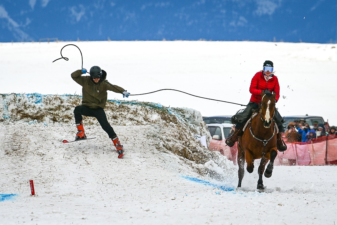 A horseback rider pulls a skier over a jump at Whitefish Skijoring on West Springcreek Road on Saturday, Feb. 22. (Casey Kreider/Daily Inter Lake)