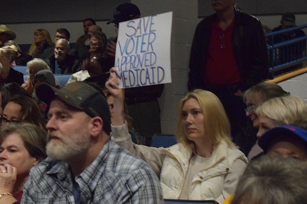 Several audience members protested in silence by holding up signs during Saturday's Legislative Town Hall.