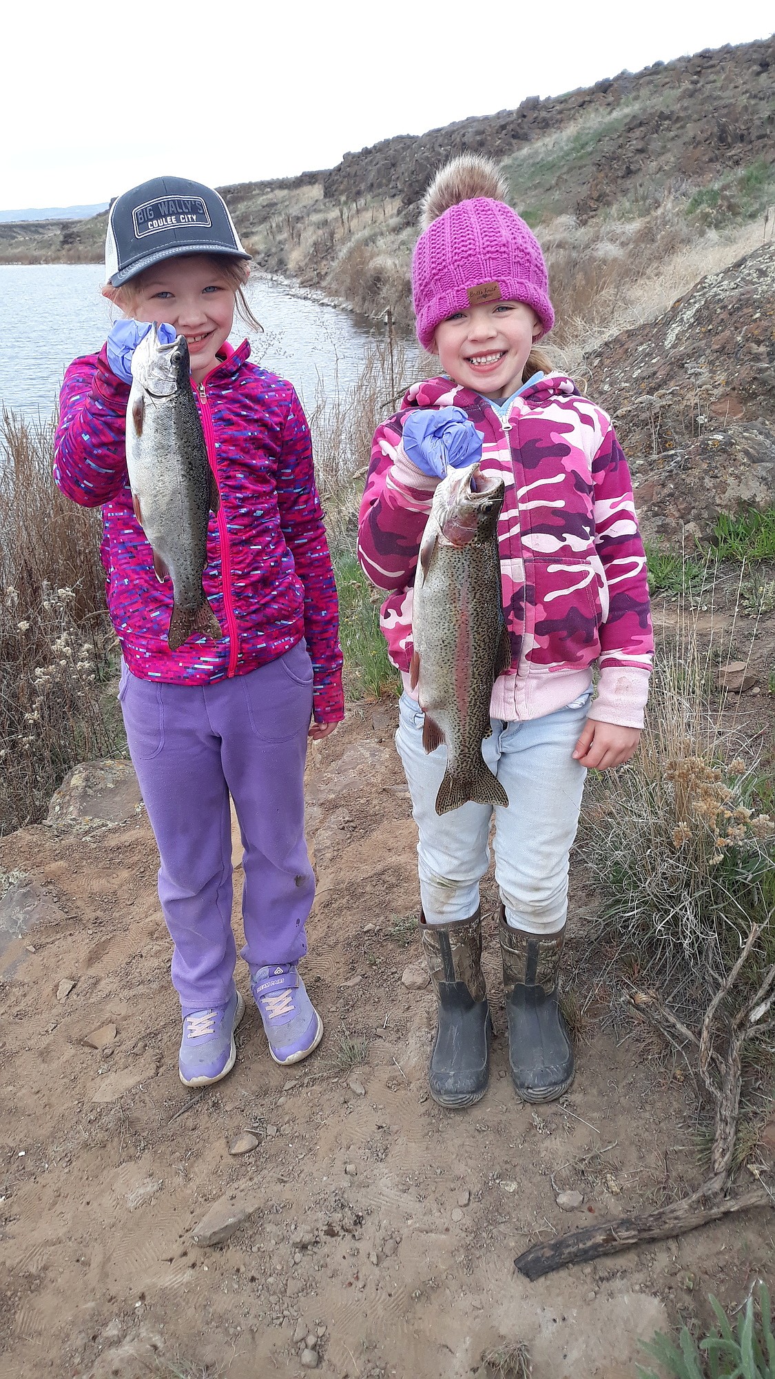At Burke Lake in Grant County, two girls dressed for the cold smile holding trout they caught fishing with their grandfather. Burke Lake is one of 14 lakes in Grant County that will open for trout fishing Saturday.