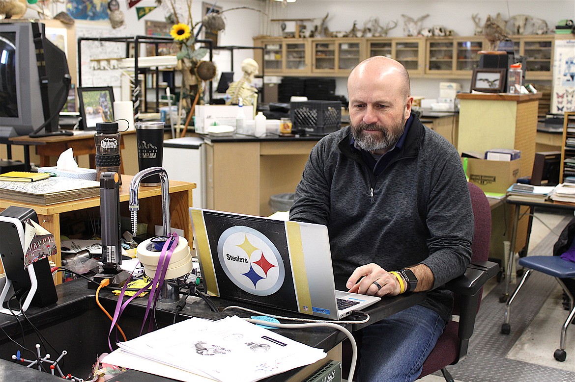 Joe Quinn works on his computer before class. (Kaleb Unger/Leader)