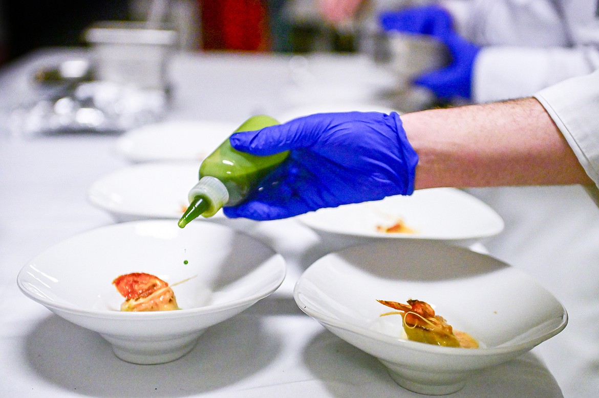 Conor Sears adds drops of lemon basil oil to a bronzed sea scallops appetizer during a Chef's Table dinner series held by Flathead Valley Community College's Culinary Institue of Montana on Friday, Feb. 21. (Casey Kreider/Daily Inter Lake)