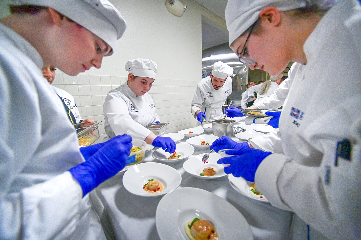 From left, Max Malcomson, Billie Melnick, Conor Sears and Kaylee Bishop add garnishes to a round of bronzed sea scallops appetizers at a Chef's Table dinner series held by Flathead Valley Community College's Culinary Institue of Montana on Friday, Feb. 21. (Casey Kreider/Daily Inter Lake)