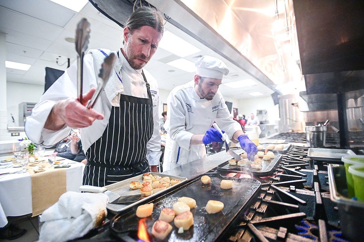 Executive chef Andy Blanton and Conor Sears sear scallops for a bronzed sea scallops appetizer served at a Chef's Table dinner series held by Flathead Valley Community College's Culinary Institue of Montana on Friday, Feb. 21. (Casey Kreider/Daily Inter Lake)