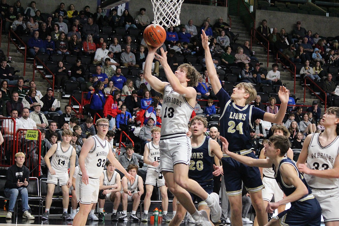 ACH’s Josh Booker (13) drives the lane against MLCA/CCS’s Johnny Ferguson (24).