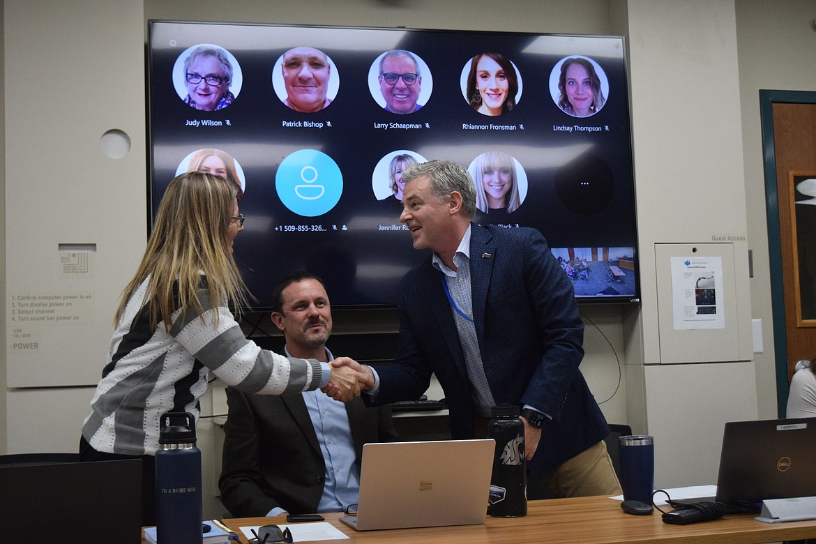Newly appointed Grant PUD General Manager John Mertlich shakes hands with Chief Administrative Officer Julie Pyper as Chief Customer Officer Ty Ehrman looks on at the PUD Commission meeting Tuesday. Mertlich starts today in the role, taking over from outgoing General Manager Rich Wallen.