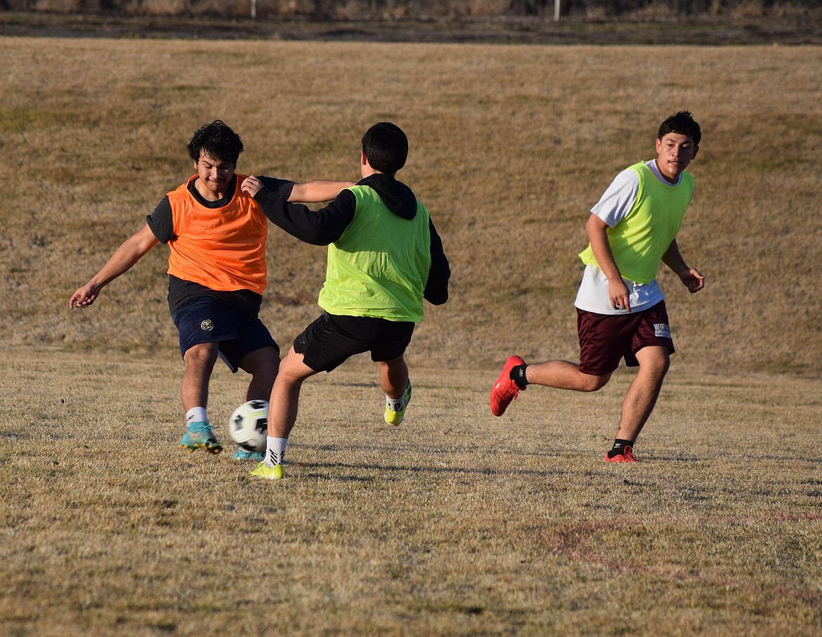 Two defenders, in yellow, work on defending against scrimmage offense on the soccer pitch last week. The Warriors soccer team has been doing extensive drills as they prep for play later this week.