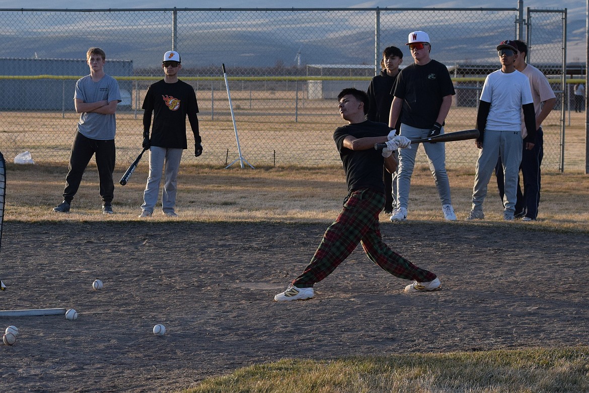 A Wahluke player finishes the follow through on a hefty swing during Friday’s practice as his teammates watch. Head Baseball Coach Chet Bangs said he wants the players to watch each other and their opponents and communicate for more successful plays this year.