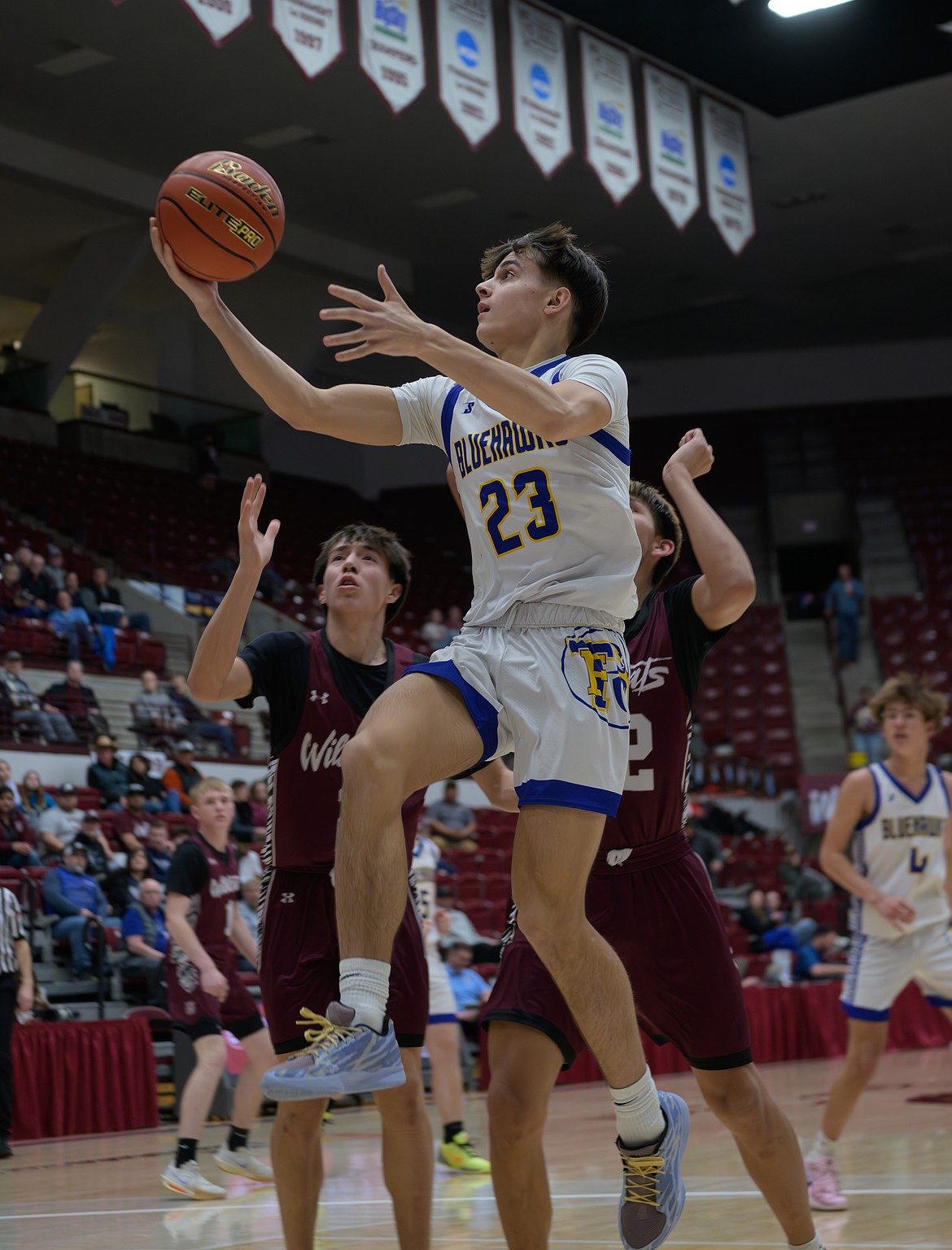 Senior guard Sam Burgess (23) goes by the Harlem defense for a layup during their game this past week in Missoula. (Tracy Scott/Valley Press)