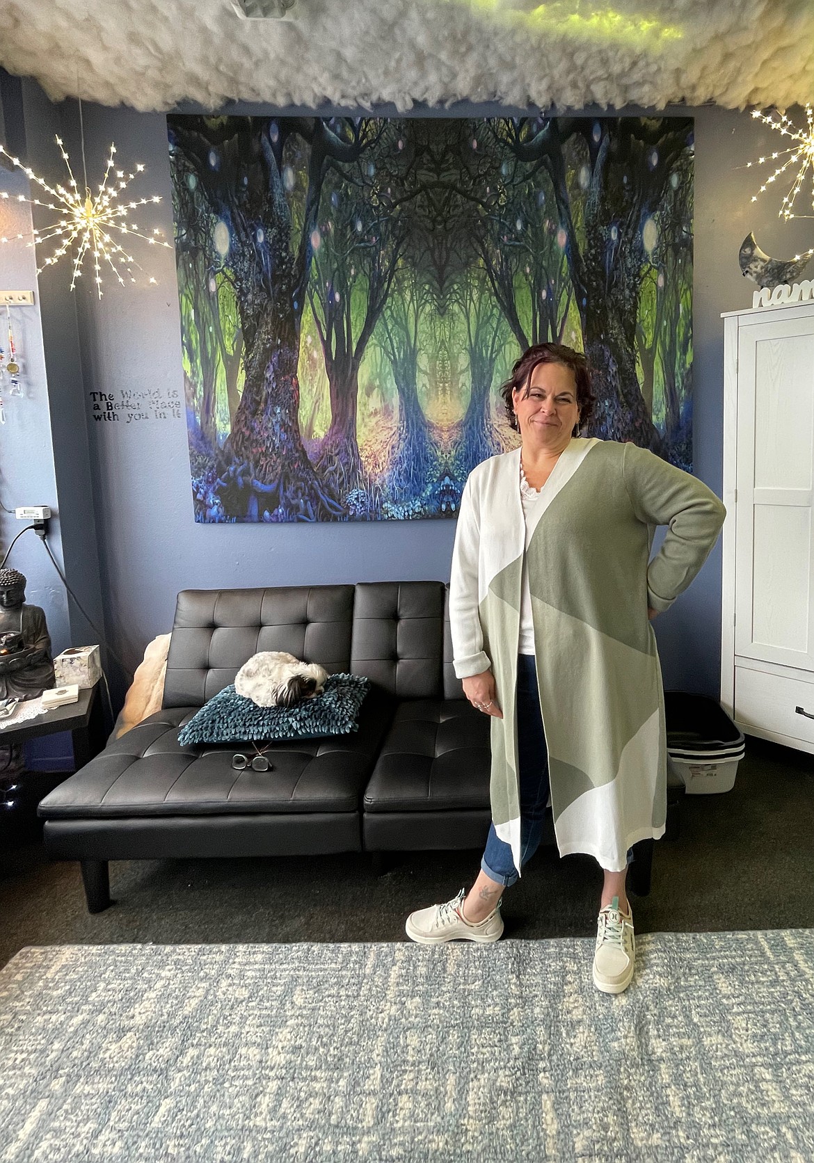 Seeds ‘n Stone owner Amy Winter and her dog Dottie pose in front of the original tapestry that Winter started her business with. Seeds ‘n Stone will be permanently closing its storefront Wednesday. Winter said she started the business at the farmer’s markets with the tapestry blowing in the wind behind them and when she moved to a building, she had the tapestry framed to remember her roots.