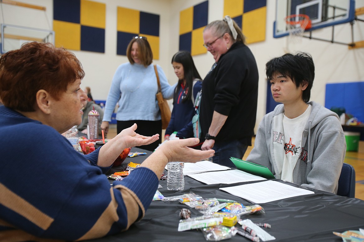 April Legard with Knudtsen Chevrolet speaks with Coeur d'Alene High School student Danny Nguyen about office administration Tuesday at the Career Exploration Fair.