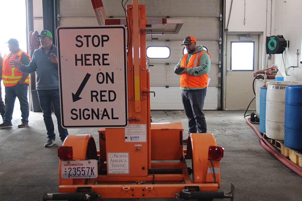 Omar Valdez demonstrates an automatic flagger used by the Washington State Department of Transportation. Valdez said inattentive drivers have hit the machine a couple of times.