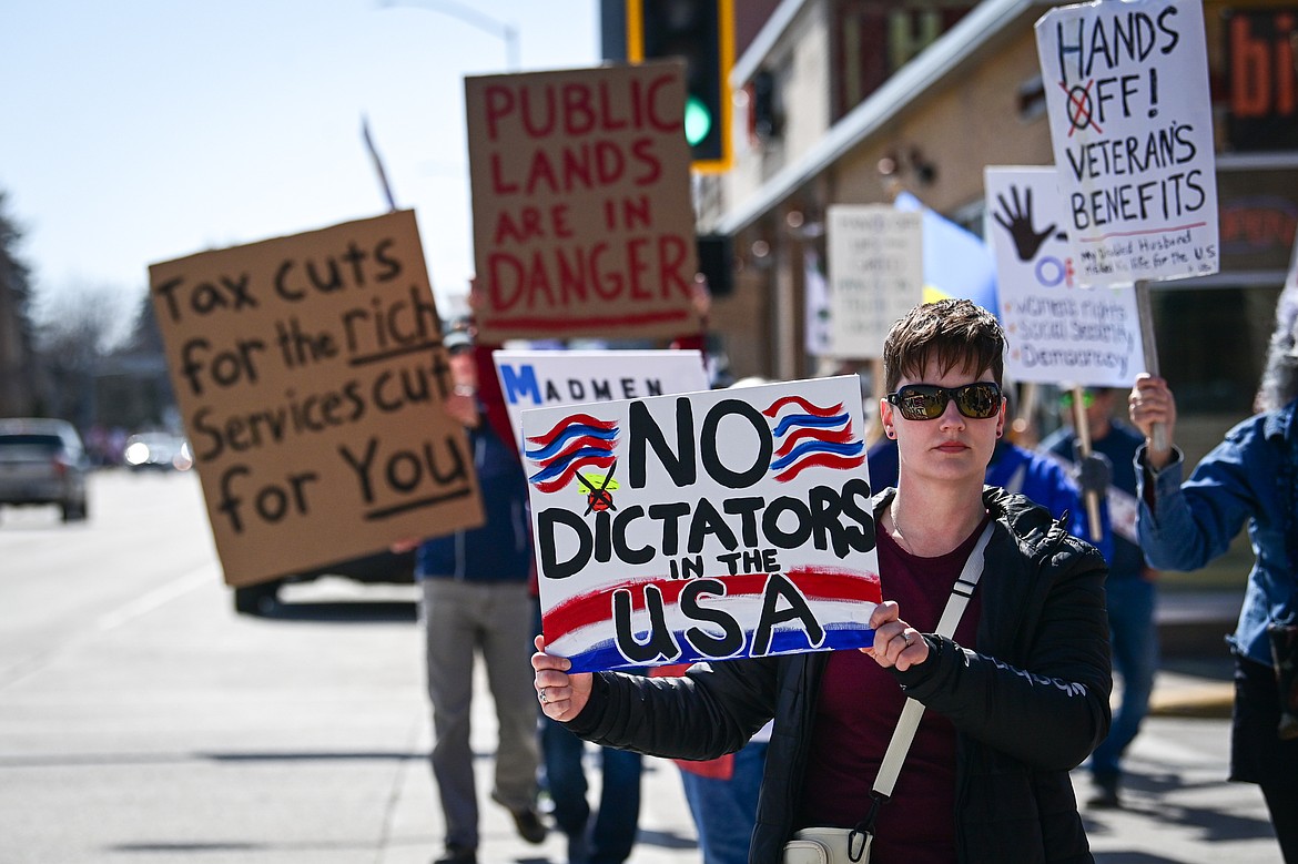 Demonstrators walk along Main Street toward Depot Park during a "Hands Off" protest in Kalispell on Saturday, April 5. (Casey Kreider/Daily Inter Lake)