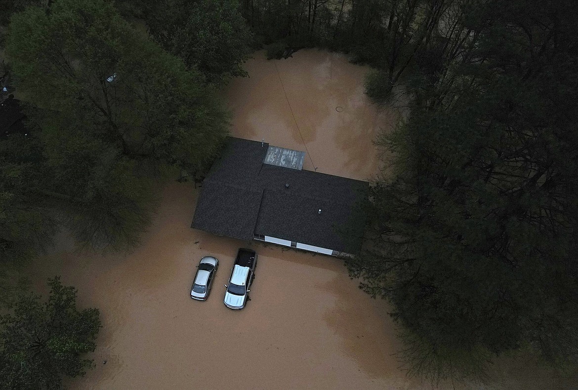 Floodwaters inundate homes and vehicles in Shannon Hills, Ark., Saturday, April 5, 2025, as a second day of storms brought widespread flooding to the region. (Colin Murphey/Arkansas Democrat-Gazette via AP)