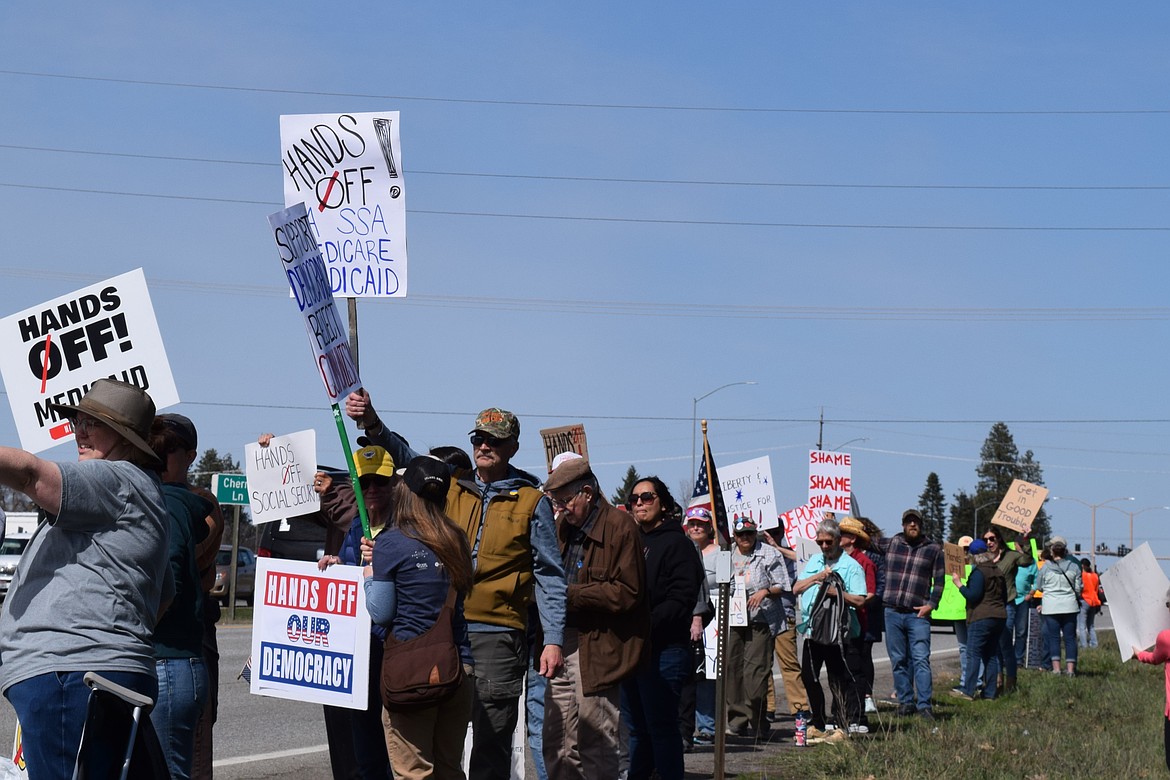 Several hundred people, many with signs, lined U.S. 95 in Coeur d'Alene on Saturday as part of a nationwide protest against the Trump administration.