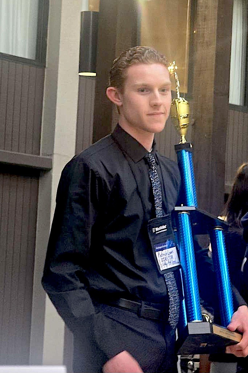 Libby Middle High School concert band director Patrick Lewis holds the trophy the Loggers won during their recent trip to Seattle, earning a Gold rating and second place overall among concert bands, in addition to the coveted Adjudicator Award at the WorldStrides Heritage Music Festival. (Courtesy photo)