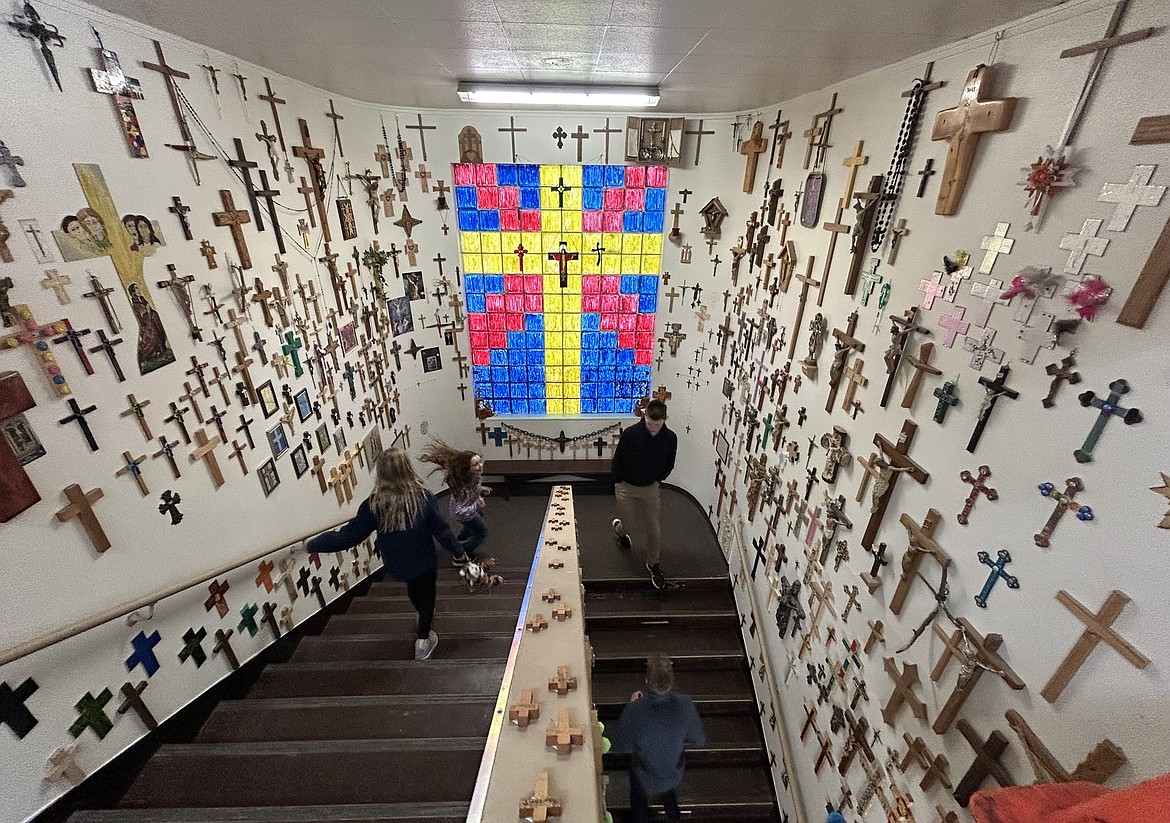 Students meeting at St. Thomas parish center walk the stairwell of the Cove of Crosses on Wednesday.