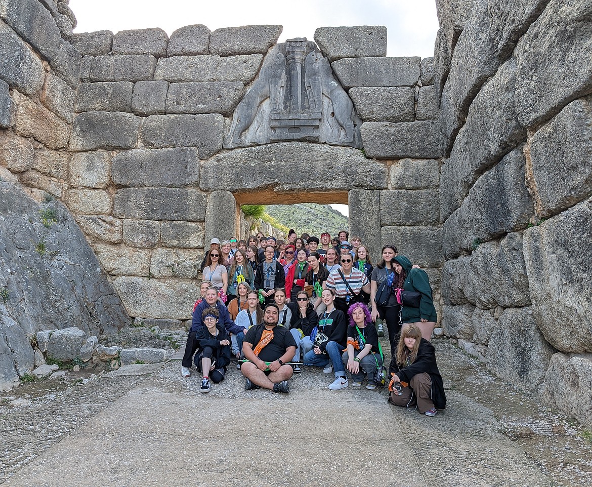 Coeur d'Alene students and chaperones pose by the gate of stone-carved lions guarding the gate of Mycenae in Greece.