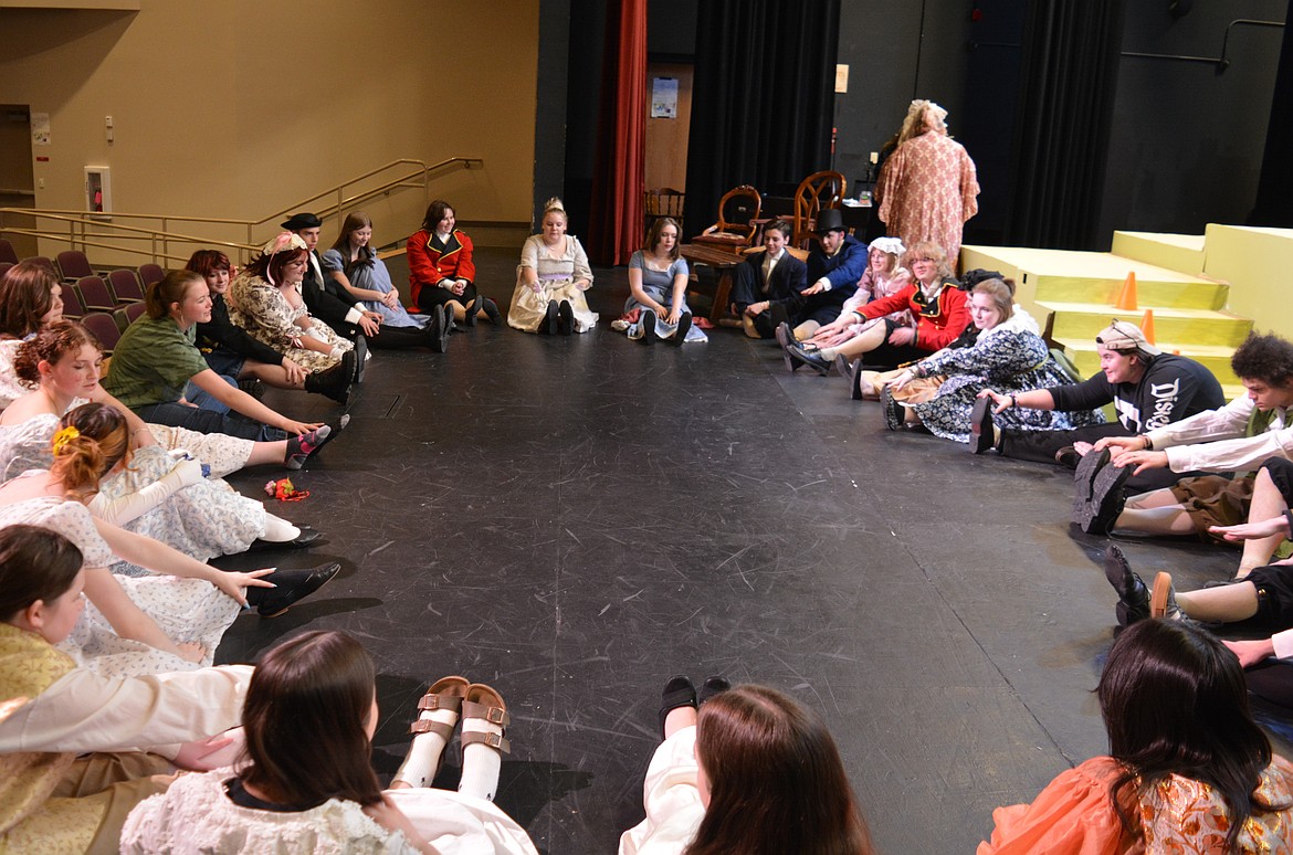 Students form a circle to stretch and warm up Monday before a rehearsal for "Pride and Prejudice" at Post Falls High School.