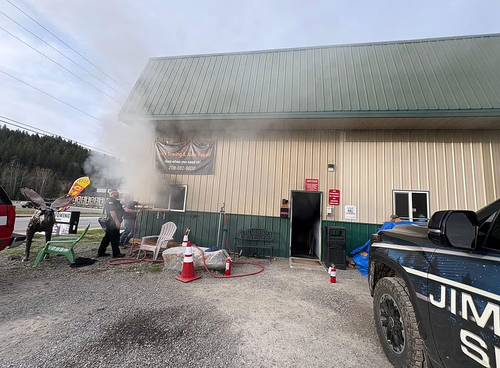 Emergency crews, including Pinehurst Police Chief John Richter, battle a fire at Jim's Towing last week.