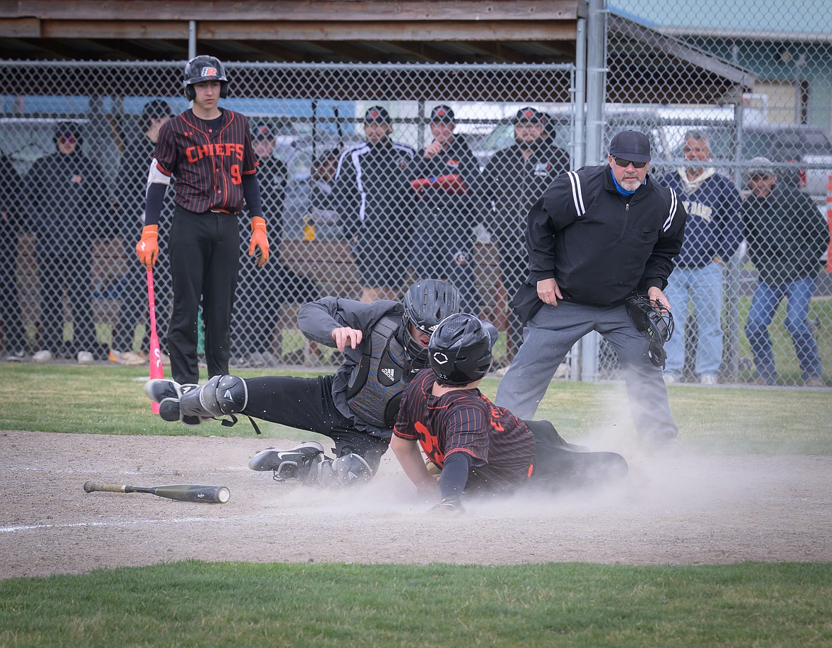 Savage Horsemen catcher Matthew Thurston (left, in catcher's gear) tries to stop Ronan's Nate Bisson from scoring in their game this past Saturday in Plains. (Tracy Scott, Valley Press)