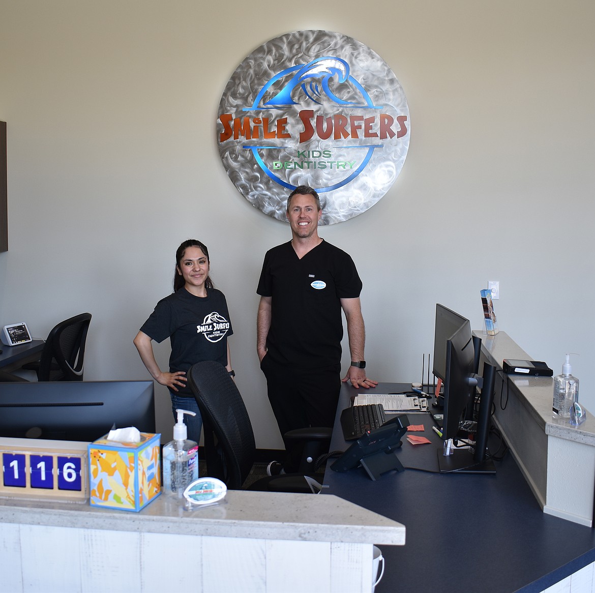 Dr. Michael Rees, right, and Administrator Assistant Paola Aguirre stand behind the desk at Smile Surfers, a new child-friendly dental clinic in Moses Lake.