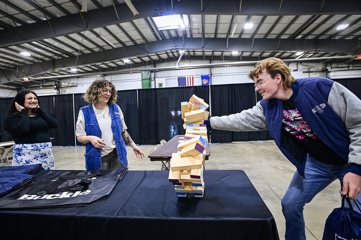Sean Sandersan, a senior from Libby High School, plays an oversized game of Jenga with Alyssa Smith and Harley May from the clothing retailer Buckle at the Northwest Montana Job and Opportunity Fair on Thursday, April 17. (Casey Kreider/Daily Inter Lake)