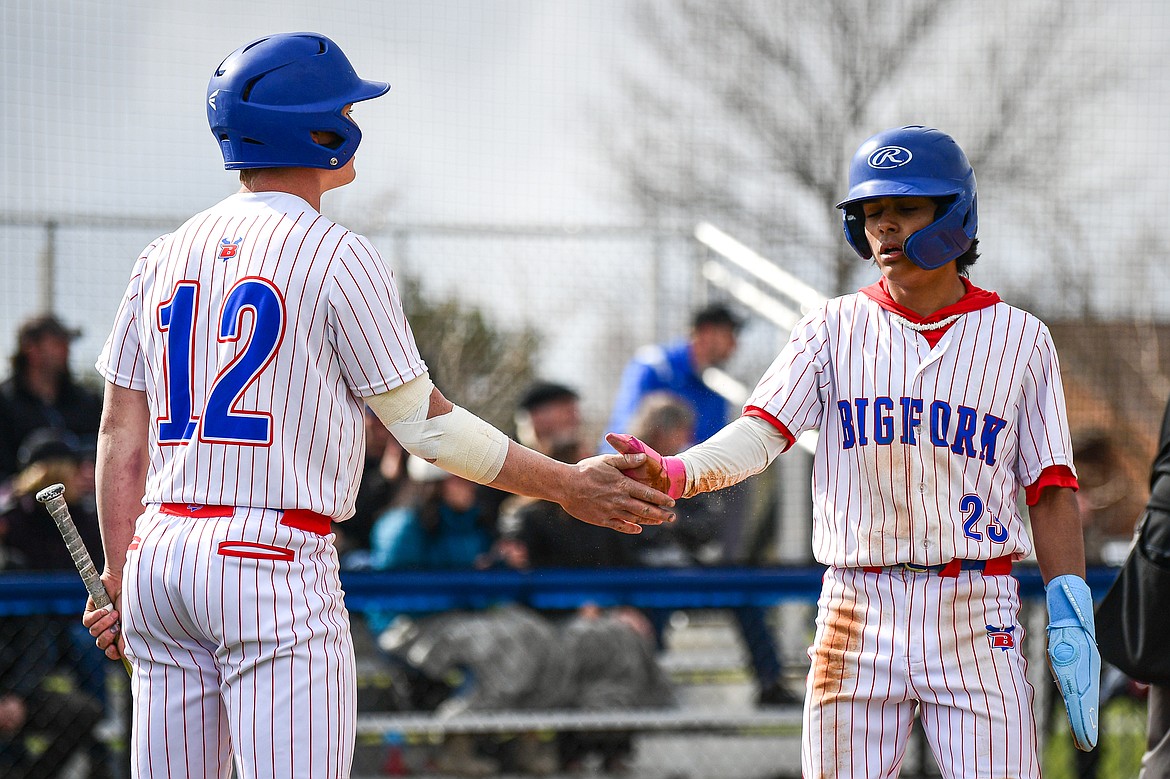 Bigfork's Sam Plummer (12) congratulates Rye Rodriguez (23) after Rodriguez scored a run against Troy at Flathead Beacon Field on Thursday, April 17. (Casey Kreider/Daily Inter Lake)