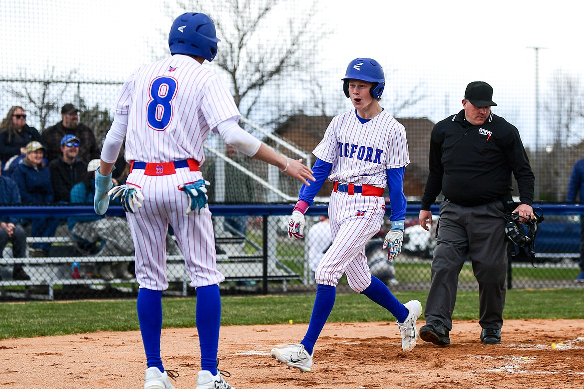 Bigfork's Grady Campbell (3) celebrates with Hayden Mayer (8) after scoring a run against Troy at Flathead Beacon Field on Thursday, April 17. (Casey Kreider/Daily Inter Lake)