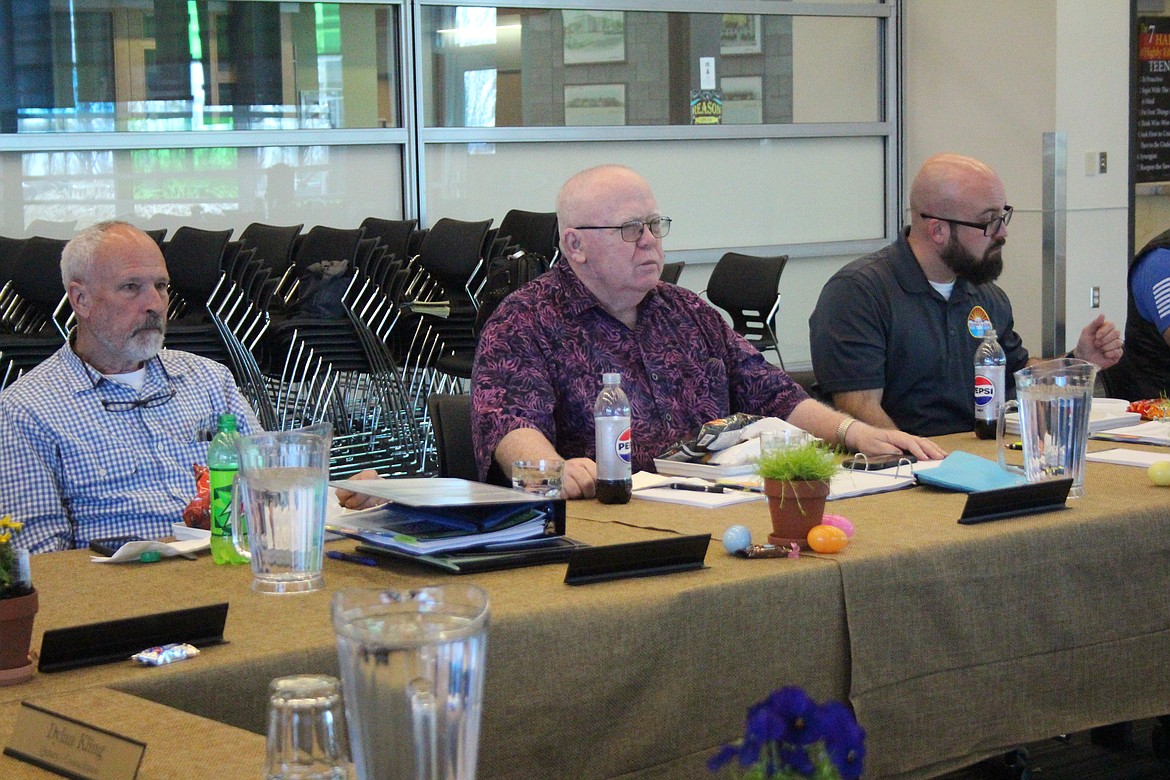 Transit authority board member Bruce Reim, center, discusses options while board members Kevin Burgess, left, and Don Myers, right listen.