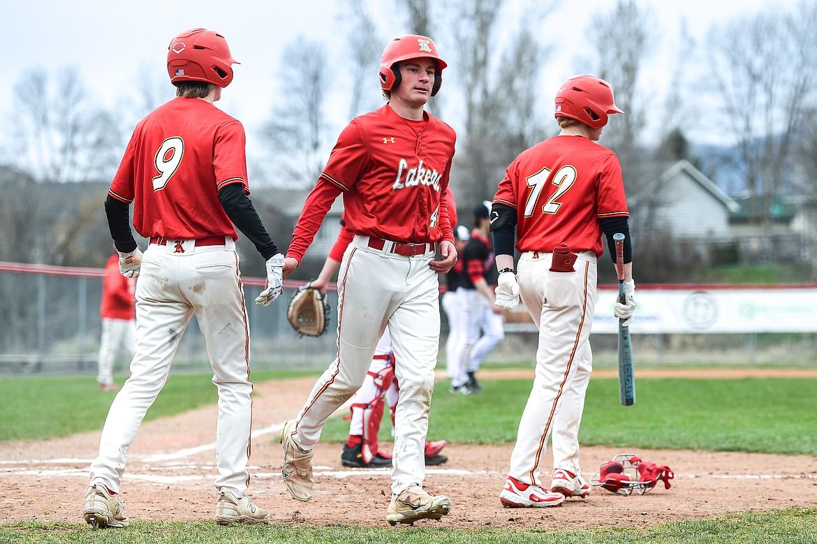 Lakers AA's Jackson Heino (4) scores on an RBI double by Hunter Fann in the second inning against the Calgary Cardinals at Griffin Field on Saturday, April 19. (Casey Kreider/Daily Inter Lake)