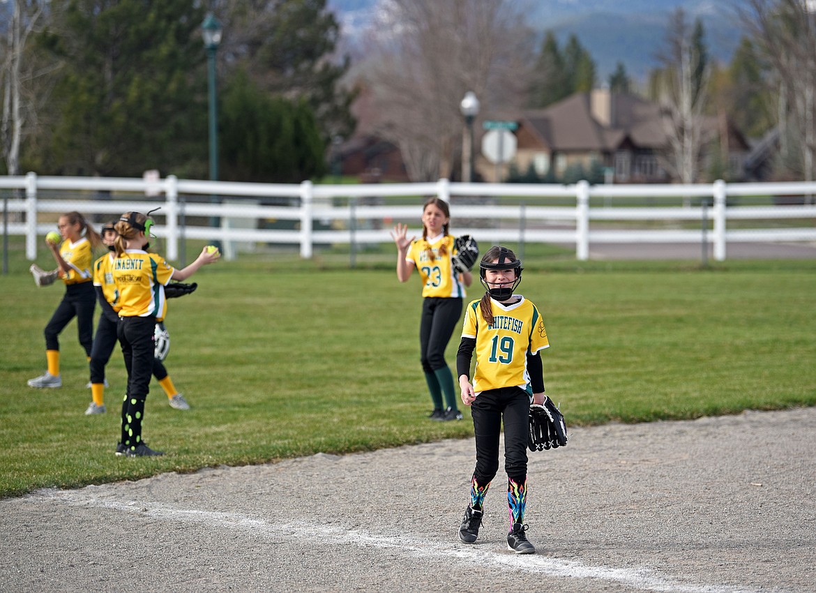 Willow Schutte and Whitefish Youth Softball 10u gold teammates practice before a game at Smith Fields last week. (Kelsey Evans/Whitefish Pilot)
