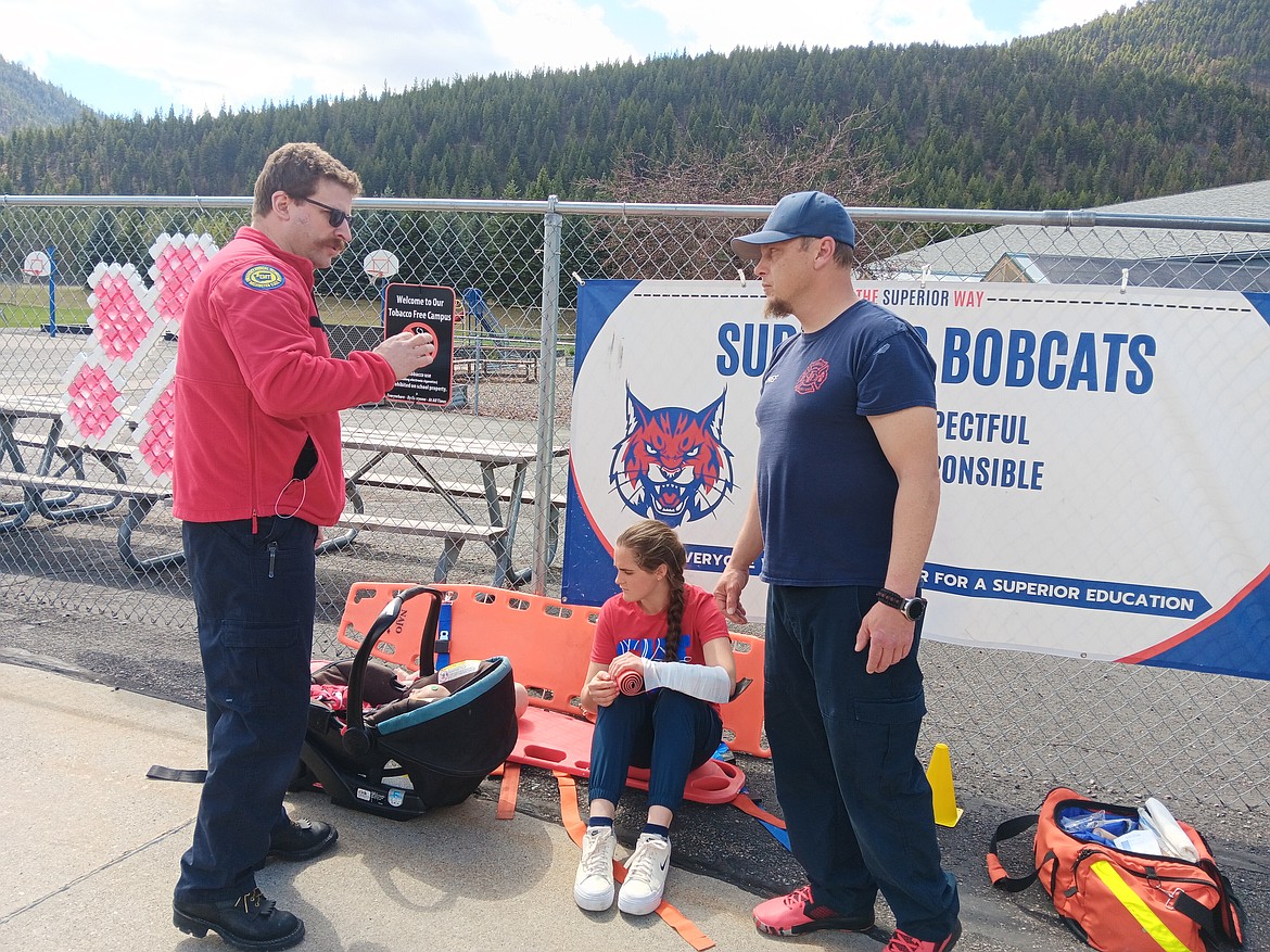 SVFD Chief Scott Dodd, right, talks with an instructor during the mass casualty incident training in the Superior Elementary School Parking lot. Josie Crabb, sitting, was one of the students participating as accident victims. (Monte Turner/Mineral Independent)