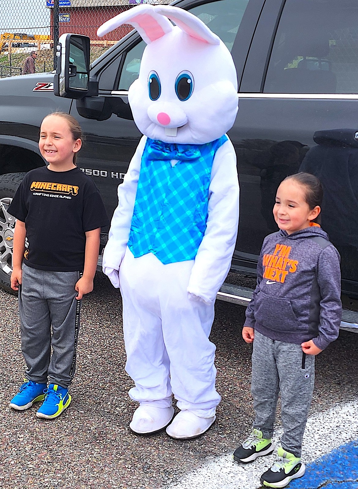 Ezekiel, 7, and Benjamin, 4, Asencio smile at their mom as they stand by the Easter bunny. (Berl Tiskus?Leader)