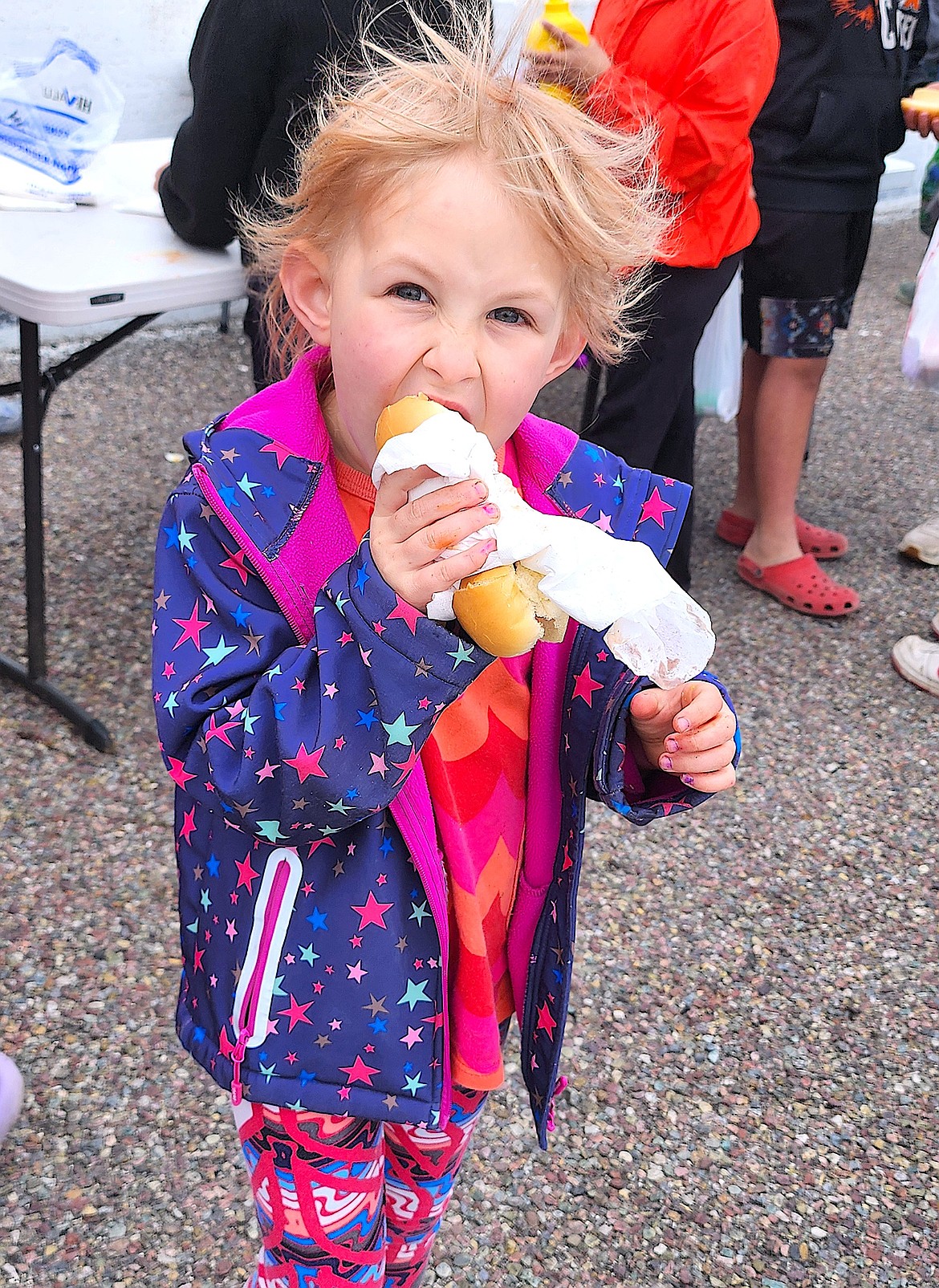 Aurelia Stahl enjoys a hot dog after searching for Easter eggs at the Mission Valley Super Oval Easter egg hunt. (Berl Tiskus/Leader)